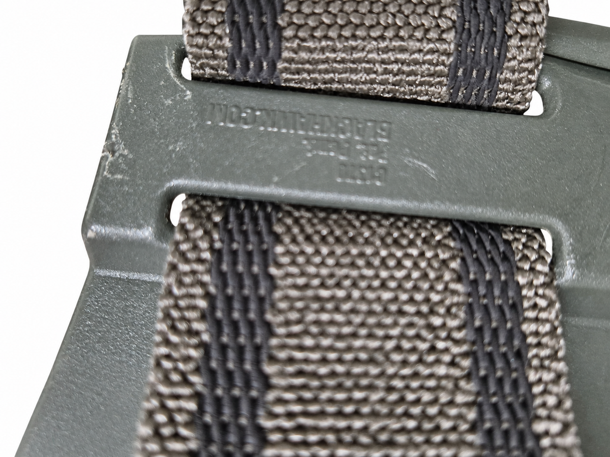 Close-up of faint molded rear-platform markings between the holster straps.
